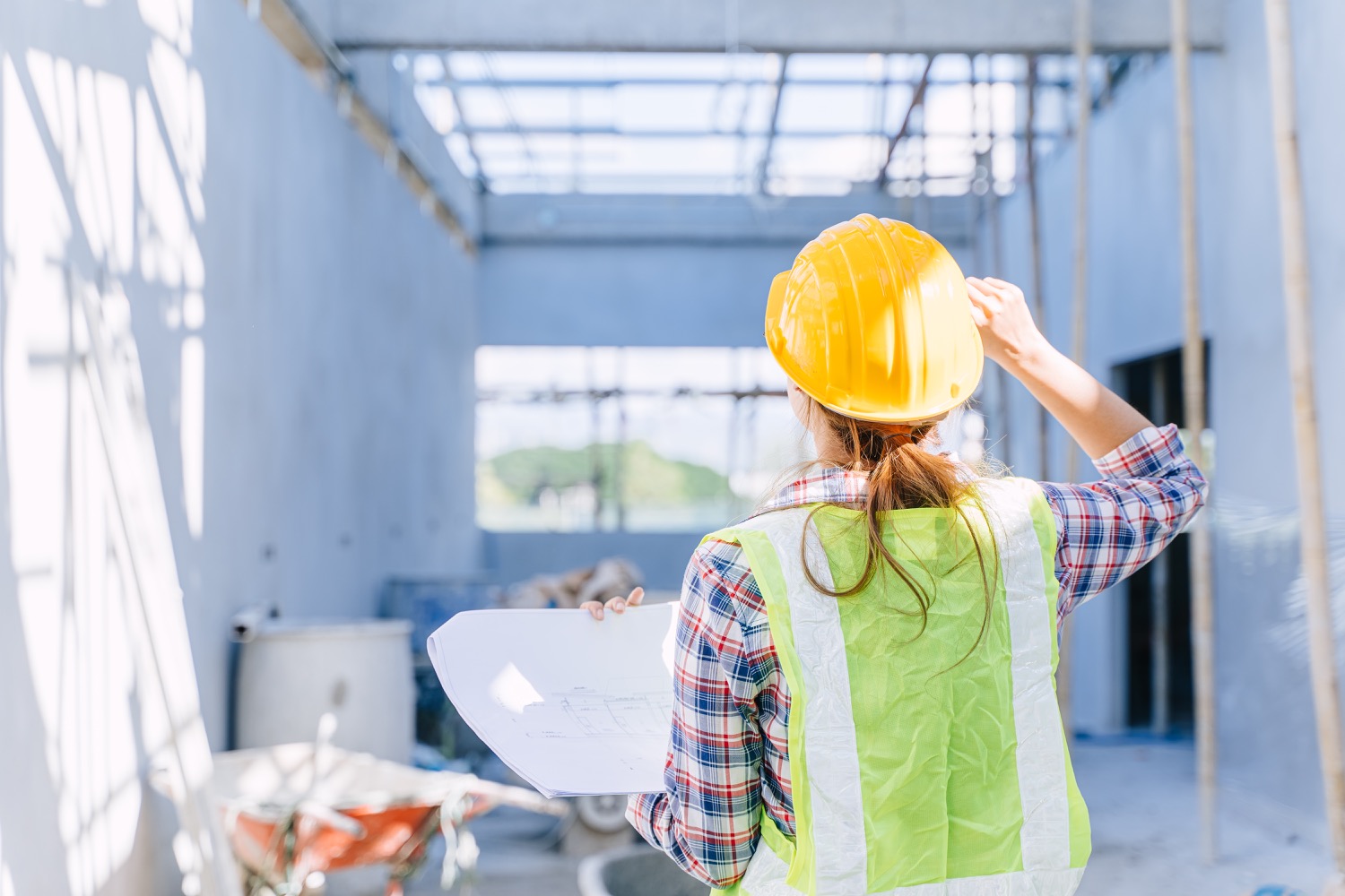 Female engineer working women. Architect construction builder worker with floor plan at building site.