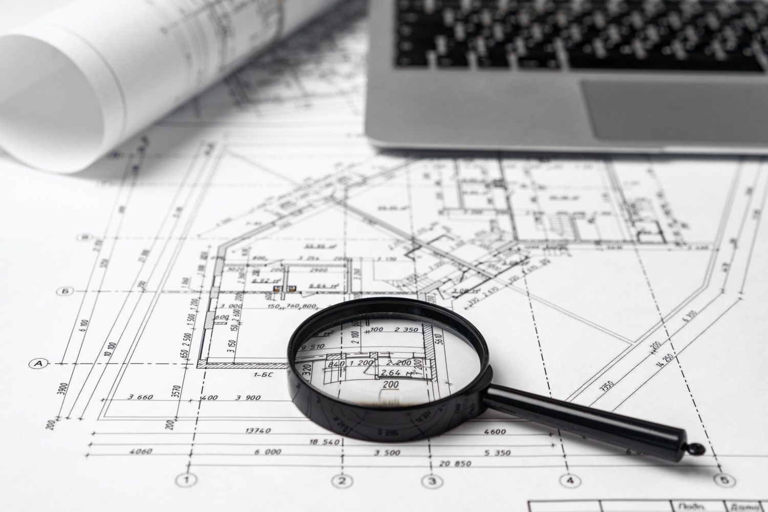 Working table of interior designer with blueprint and laptop